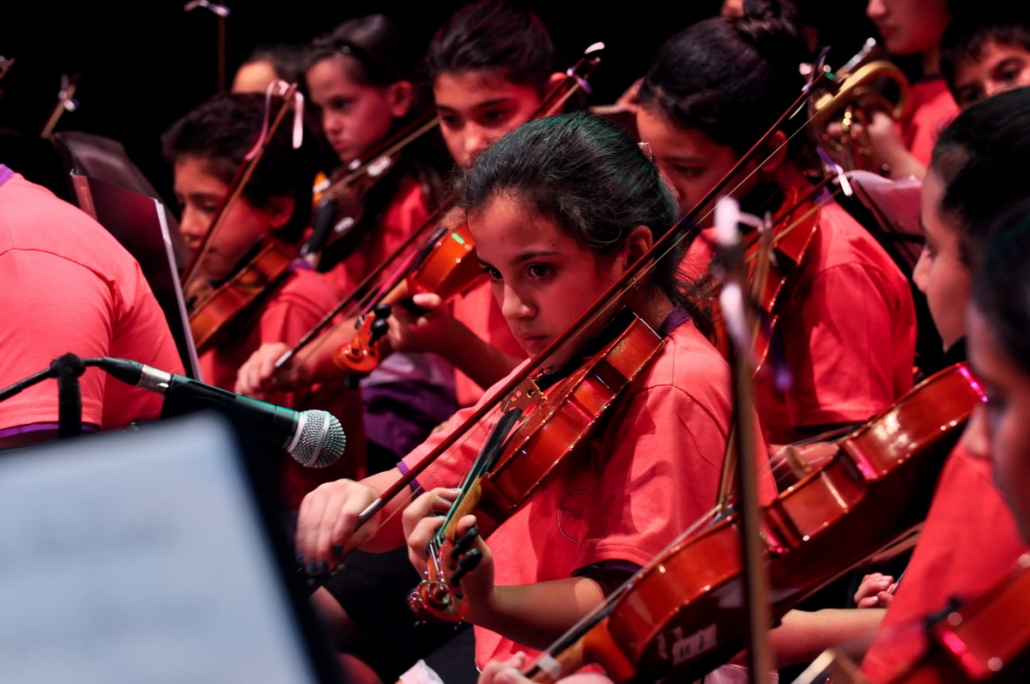 Sección de violines de la orquesta infantil durante un concierto