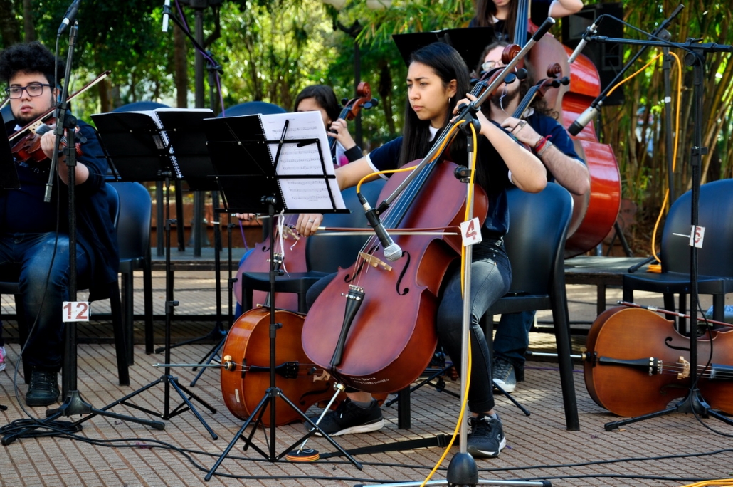 Chicos tocando el violonchelo al aire libre
