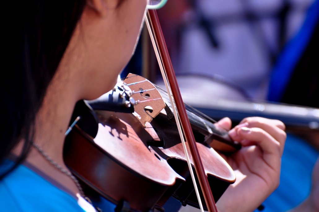 Primer plano de las manos de un joven tocando el violín