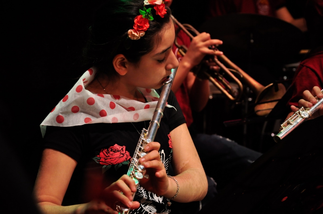 Niña tocando la flauta traversa en un concierto